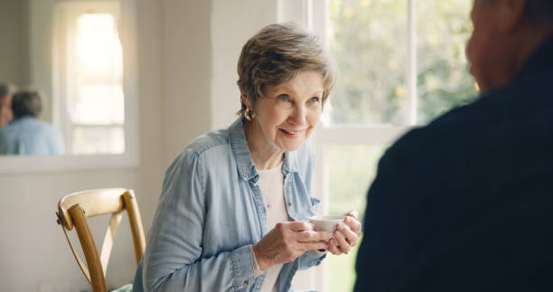 istock Happy, coffee or elderly friends in home talking, bonding or enjoying conversation on break together. Smile, support or person in retirement speaking or drinking tea to chat with an senior woman 1854509656