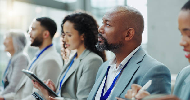 istock Business people, diversity and meeting in team workshop, seminar or conference at office. Group of employees or audience listening to speech in staff training, presentation or convention at workplace 1854517246