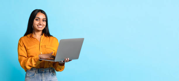 istock Middle Eastern Young Woman Posing With Laptop Computer, Blue Background 1854526917