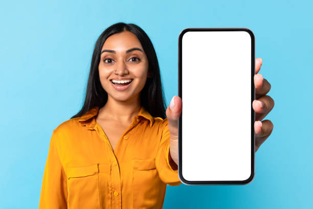 istock Hindu woman holding smartphone with blank screen on blue background 1854528533