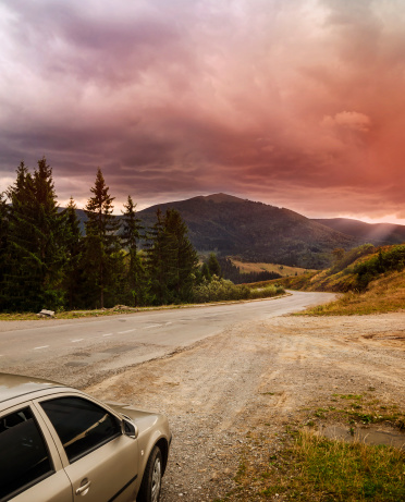 Road in the mountains. View of the mountains covered with clouds during sunset.