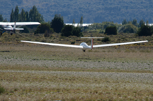 glider on land aerodrome ready to take off. gliding ultralight aircraft being towed