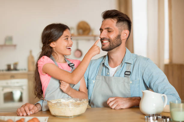 istock Excited father and daughter bonding while cooking and baking together in kitchen, cooking pastry and having fun 1854538360