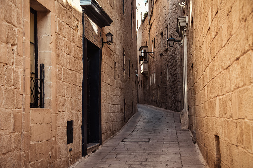 Uphill Street Between Medieval Buildings In Old Town Mdina, Malta