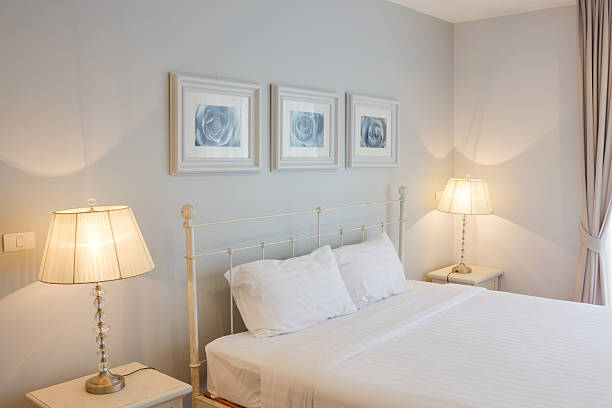 istock An all white bedroom with two switched on lamps 185456471