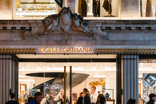 London, UK - 11 December, 2023: exterior architecture and storefront of the Dolce & Gabbana store in New Bond Street in central London, UK. The store is illuminated at night.