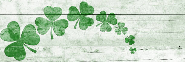 istock St Patricks day background. Shamrocks over a light green wood background. Decoration for St. Patrick's Day. Banner design 1854605437