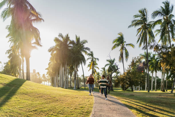 istock Child boy running with his parents in public park 1854606515