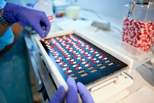 Packing white and red capsules in a sorting machine stock photo