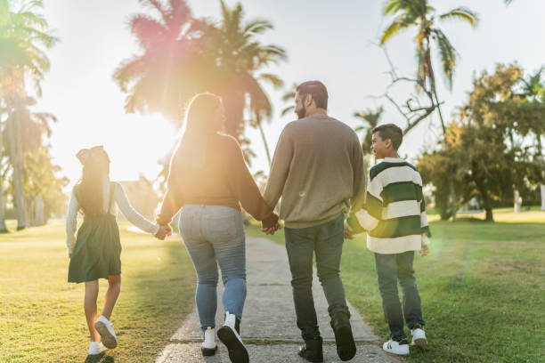 istock Family talking while walking through the public park 1854610779