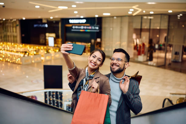 istock Happy couple taking selfie while shopping at the mall. 1854613458