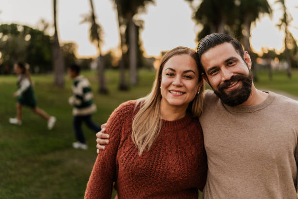 portret pary dorosłych w publicznym parku - looking at camera two parent family latin american and hispanic ethnicity heterosexual couple zdjęcia i obrazy z banku zdjęć