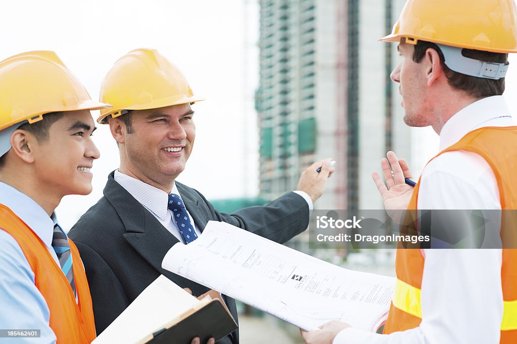 Working process Image of constructor engineers busy with work on the foreground Adult Stock Photo
