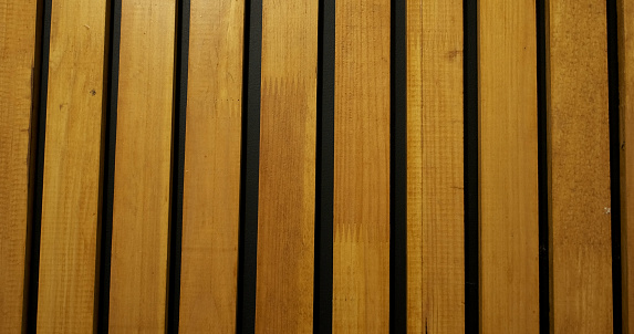 Lacquered wooden slats. Black wall with decor. Surface, abstraction, room interior. High quality photo