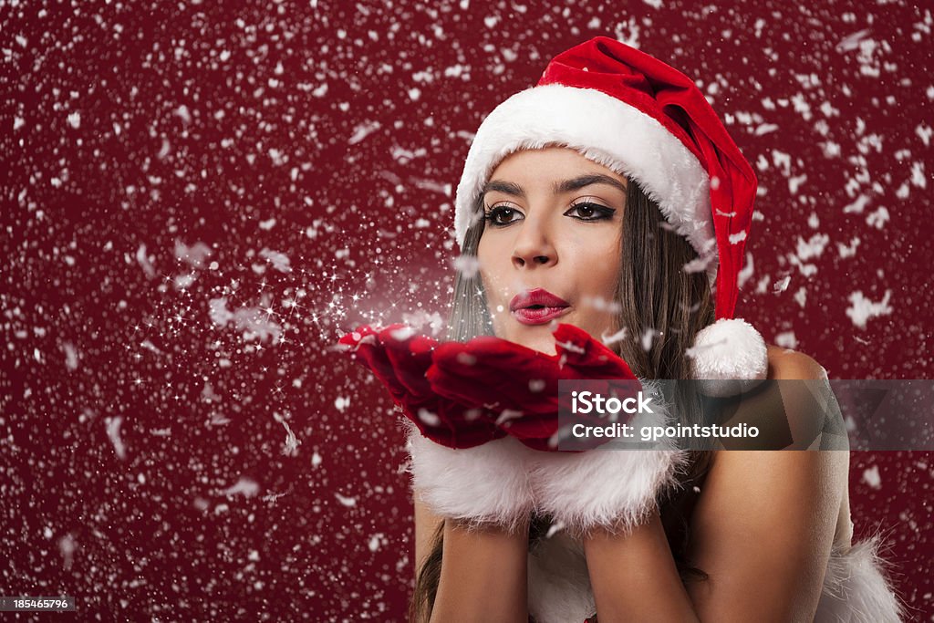 Beautiful santa claus woman blowing snowflakes Beautiful santa claus woman blowing snowflakes  Christmas Stock Photo