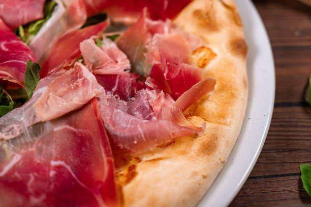 pizza with prosciutto crudo, arugula and parmesan