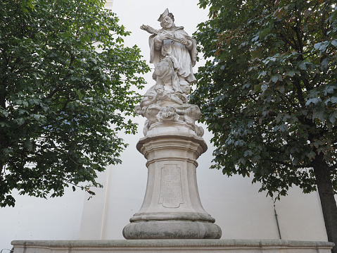 A statue of a female carrying a container with flowers, garden decoration.