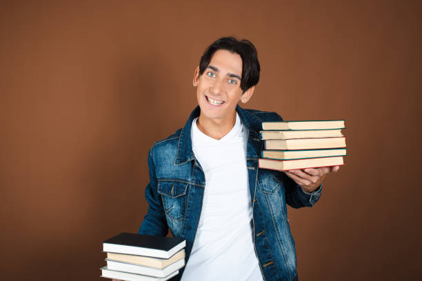 istock Young man and study. Funny attractive guy posing on a brown background. 1854713556