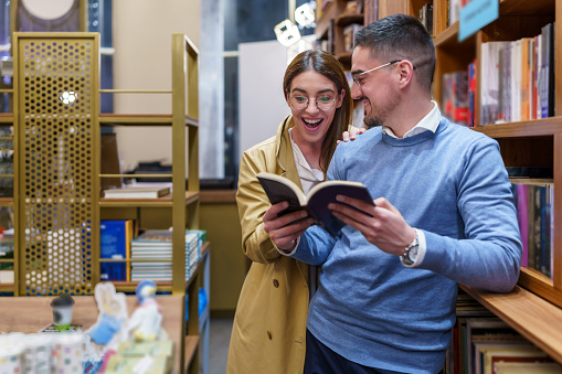 Boyfriend and Girlfriend Immersed in Book Selection at a Quaint Bookstore