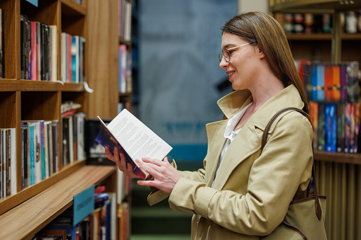 Young Woman Curiously Selecting Books in an Enchanting Bookstore