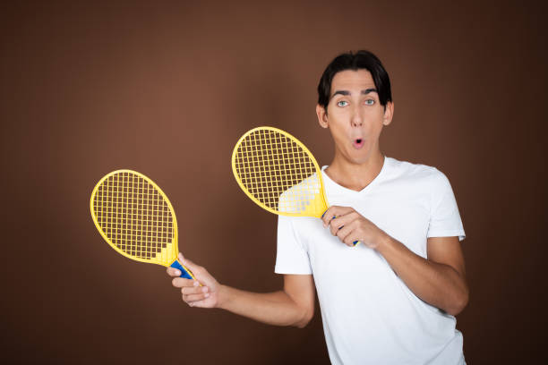 Hand holding tennis racquet on white background