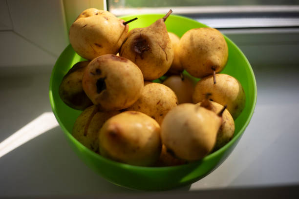 Pear in a plate. Fruit in the kitchen. Eating at home. Useful fruits. Pears in a plate on the window.