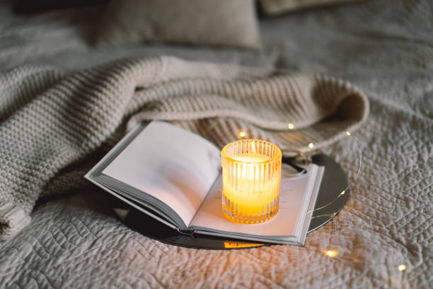 istock Scented candle with an open book in bed 1854777801