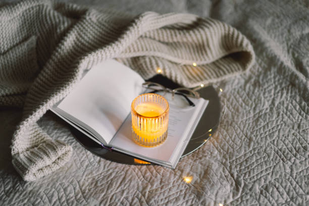 istock Scented candle with an open book in bed 1854777805