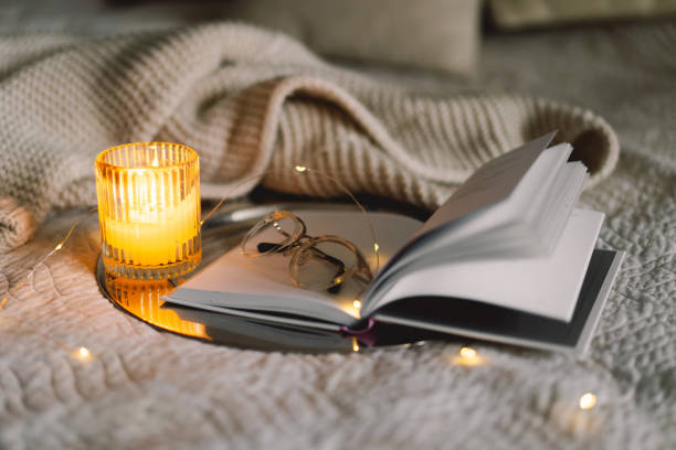 istock Scented candle with an open book in bed 1854778353