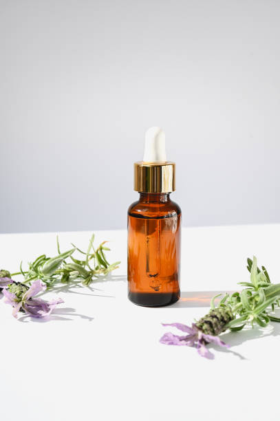 istock oil dropper bottle with flowers on white background. 1854795417