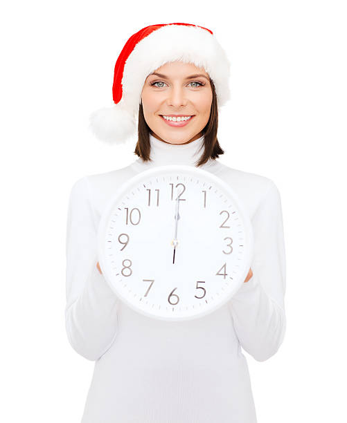 istock woman in santa helper hat with clock showing 12 185479581