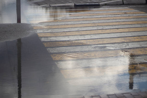 istock Puddle at a pedestrian crossing. Pedestrian markings on the highway. 1854796548