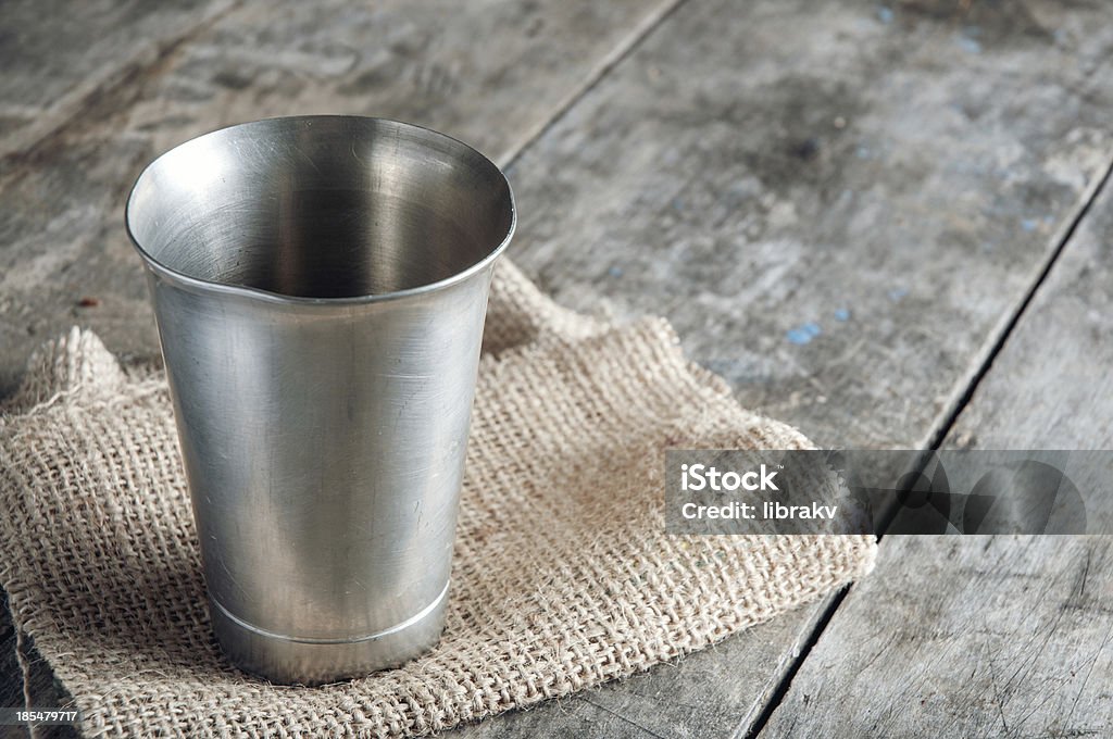 Vecchio metallo tazza sul tavolo di legno - Foto stock royalty-free di Stagno - Metallo