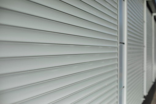 Blinds on window. Shutters on windows of office. Grey shutters. Blinds made of plastic.