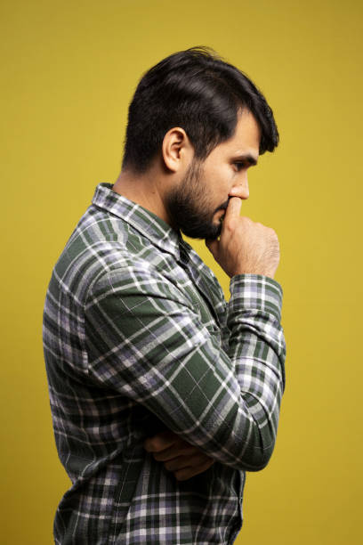 istock man in profile, with hand over mouth, thoughtful 1854851501