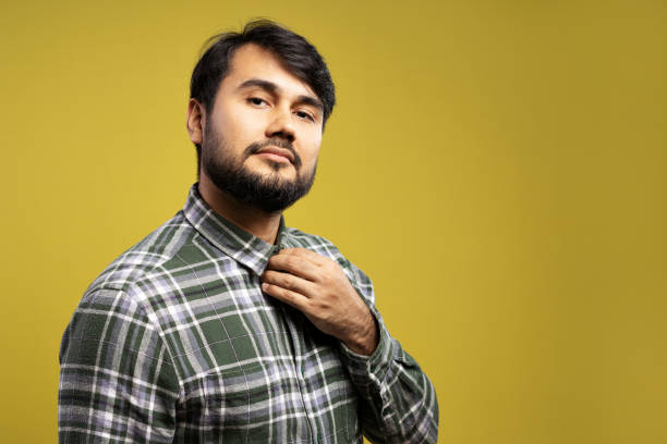 istock serious man fixing the collar of his button-down shirt 1854851502