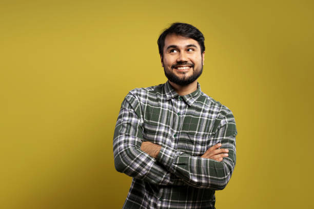 istock man with arms crossed, smiling and looking to the side 1854852051
