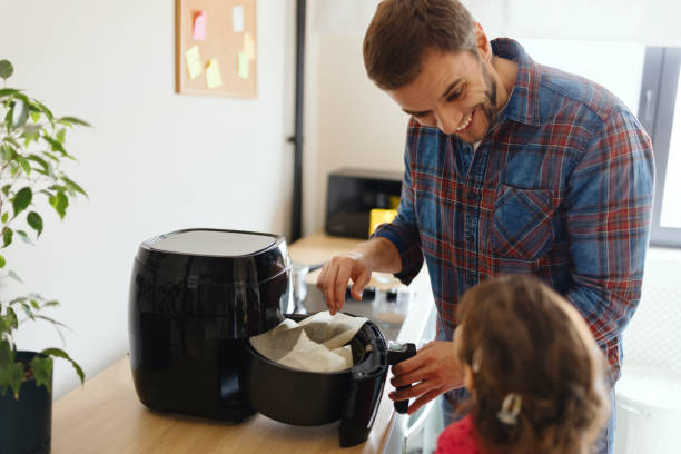 istock Little girl preparing breakfast with her father in the kitchen 1854854255