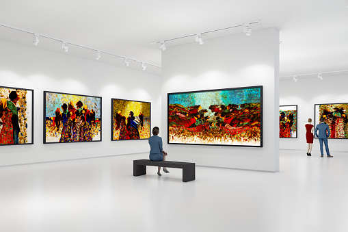 In an art center, visitors looks at the artist's collection. Modern colorful paintings on exhibition.