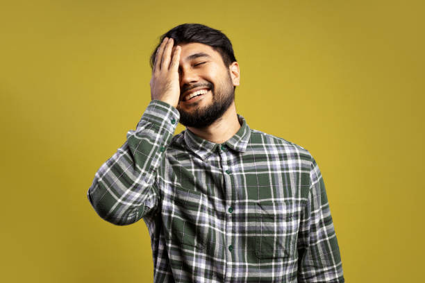 istock man with eyes closed, smiling, with his hand touching his face 1854857528