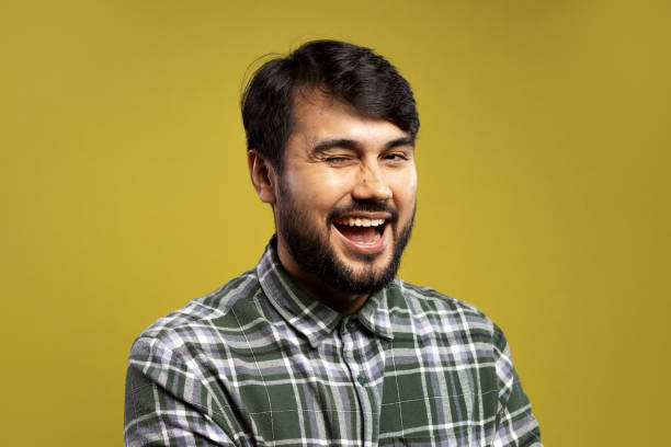 istock man winking, with an open smile and looking at the camera 1854857530