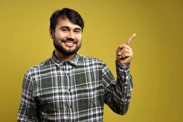istock man smiling and pointing to the side 1854861224