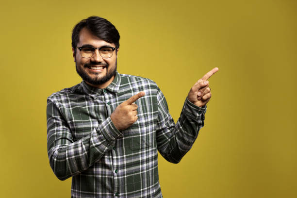 istock man smiling and pointing to the side with both hands 1854862323