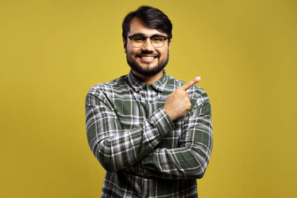 istock man smiling and pointing to the side 1854862919