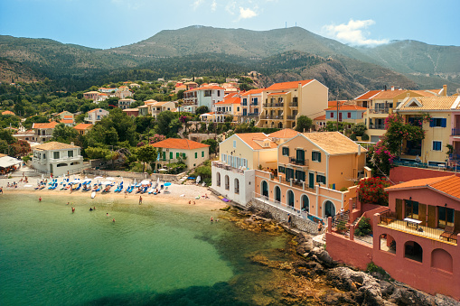 A beautiful small town of Assos on Kefalonia island, on a peaceful summer day. A lovely bay with sailboats, and a bunch of small, traditional mediterranean houses