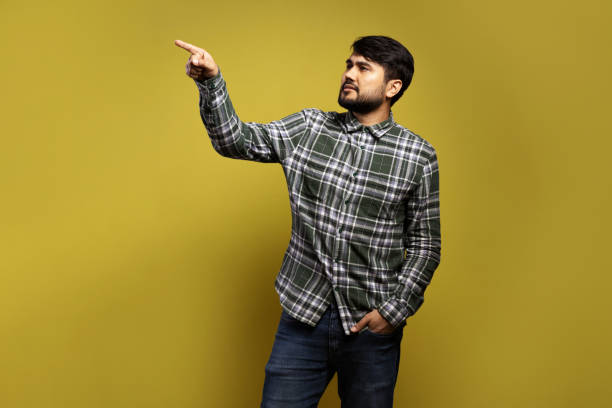 istock man looking to the side, with his hand in his pocket and pointing 1854863444