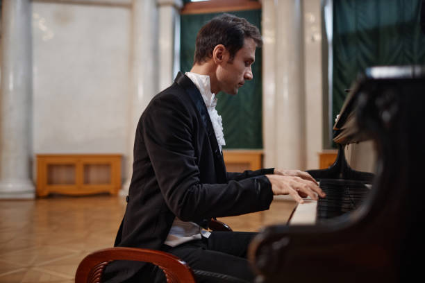 istock Elegant Gentleman Playing Piano in Palace Hall 1854864511