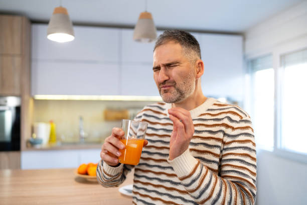istock Caucasian man with toothache making a grimace after he drinks a cold orange juice 1854867761