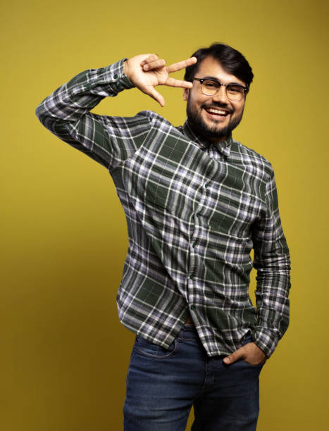 istock man smiling, with his hand in his pocket and making the peace symbol 1854874652