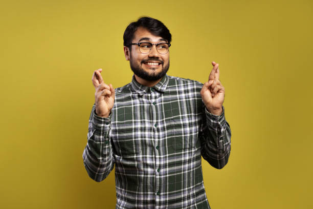 istock man looking to the side and crossing his fingers 1854874664